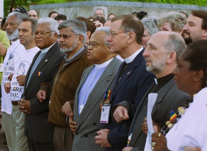 protesters stand arm in arm in front of building entrance